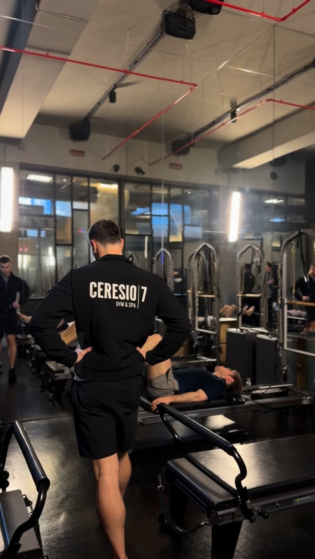 Istruttore che segue un esercizio di Pilates in studio